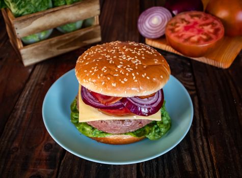 Hamburger and ingredients in composition on wooden background