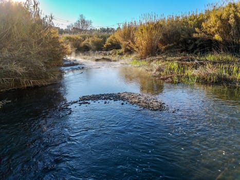 River with water evaporating on a very cold morning in the mountain