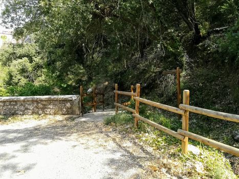 Natural landscape with round wooden fences and a stone wall