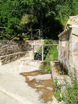 Stone fountain in the middle of nature with wooden walls and fences