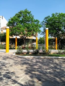 Park with yellow columns, trees in the background and with the stone floor