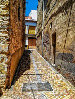 Narrow alley with soil and stone houses