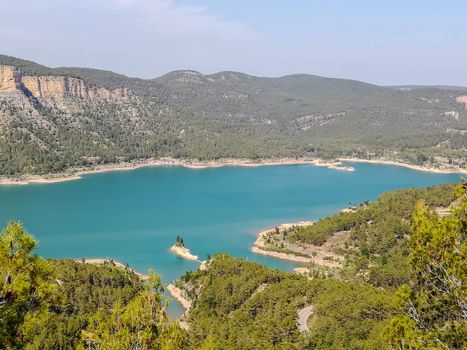 View of Puebla reservoir with mountains in the background and a pine forest