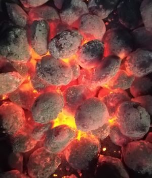 Incandescent coals in reddish, orange and yellow tones