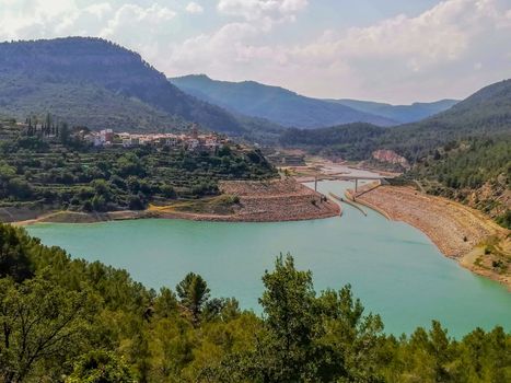 View of Puebla reservoir with mountains in the background and a pine forest