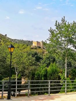 View of the ancient castle of Gaibiel with the forest below and the cloudy sky