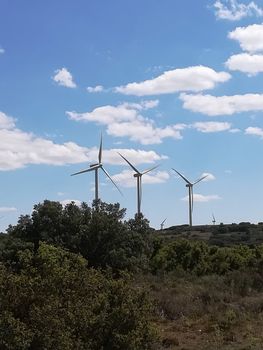 Wind generators on the mountain with blue sky in the background
