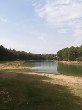 View of Puebla reservoir with mountains in the background and a pine forest