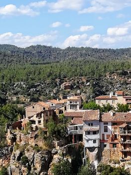 Ancient hanging houses of the mountain village of Fuente de la Reina with mountains in the background