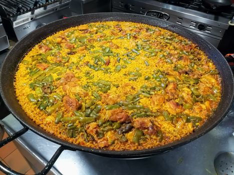 Typical Spanish food of rice, meat and vegetables in special flat casserole for this meal