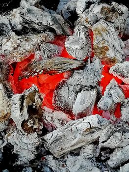 Incandescent coals in reddish, orange and yellow tones