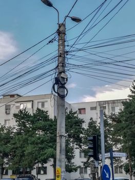 Pole of a light with many disorganized coiled cables in Buzau