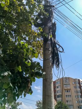 Pole of a light with many disorganized coiled cables in Buzau