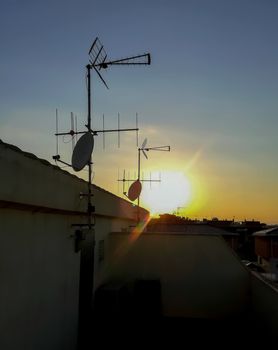View of the sun setting from a terrace with several satellite dishes in Alquerias
