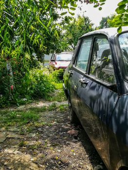 View of two antique cars in a garden in Romania