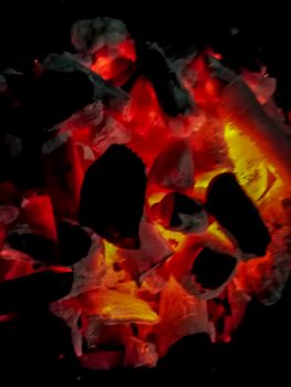 Incandescent coals in reddish, orange and yellow tones