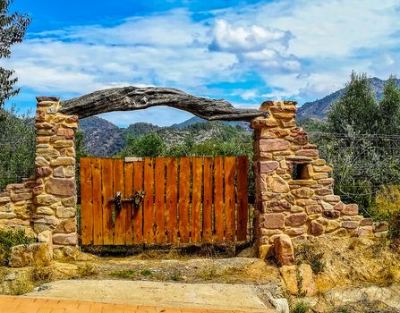 Nice rural stone door with a crossbar trunk and the mountains in the background