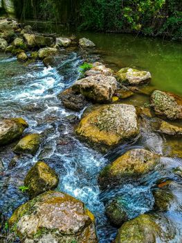 Rocks forming a small dam in the Palancia river as it passes through Segorbe