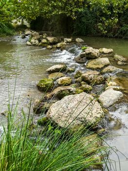 Rocks forming a small dam in the Palancia river as it passes through Segorbe