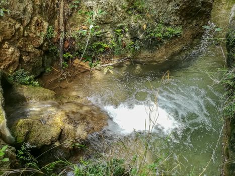 Small pond with crystal clear water surrounded by rocks