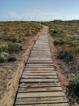 Wooden walkway to access the beach with the Mediterranean Sea in the background