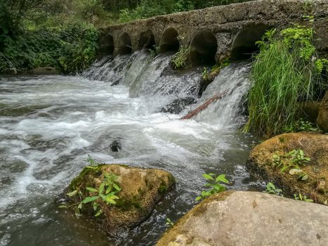 Bridge with water flowing through it by cylinders in Navajas
