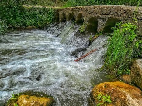 Bridge with water flowing through it by cylinders in Navajas