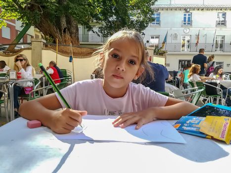 Navajas, Spain 10/12/2018: Little girl drawing in a crowded square