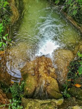 Small pond with crystal clear water surrounded by rocks