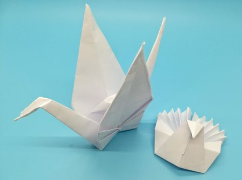 Origami figures made with white paper on blue background