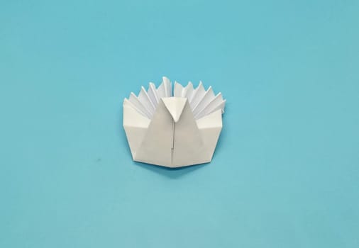 Origami figures made with white paper on blue background