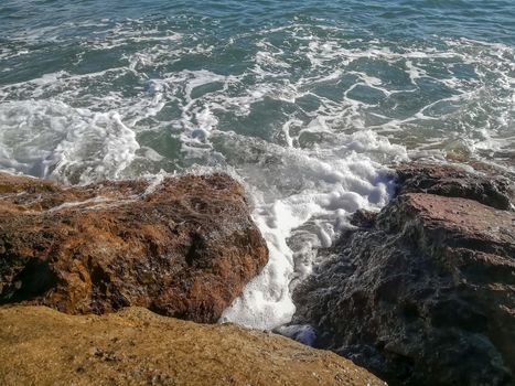 View of the Mediterranean sea breaking against the rocks generating sea foam