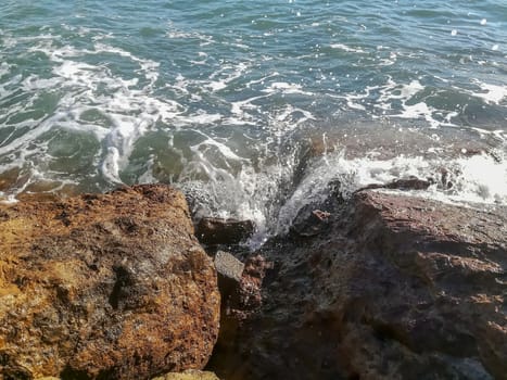 View of the Mediterranean sea breaking against the rocks generating sea foam