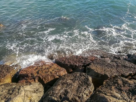 View of the Mediterranean sea breaking against the rocks generating sea foam