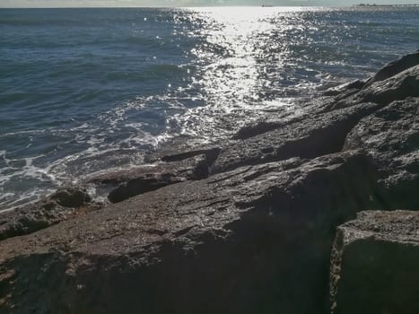 View of the Mediterranean sea breaking against the rocks generating sea foam