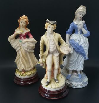 Ceramic figures of people on black background