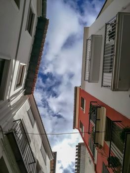 View from below of buildings with clouds sky
