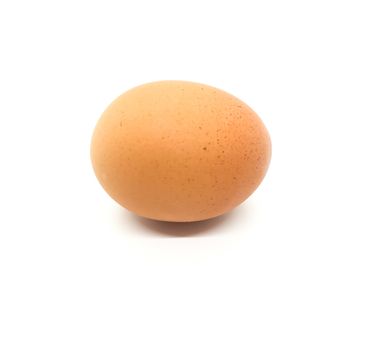 Brown egg with black specks on white background