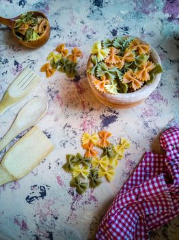 Colorful pasta ties in composition on light and rough background
