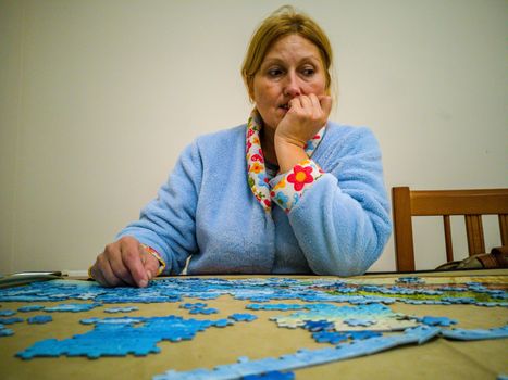 Woman in lab coat making puzzle at home