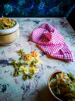 Colorful pasta ties in composition on light and rough background