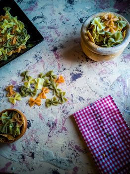 Colorful pasta ties in composition on light and rough background