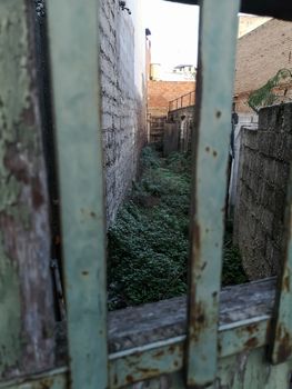 Alley hidden behind a door with a window with gates