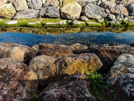 Rocks reflected in the water on the beach