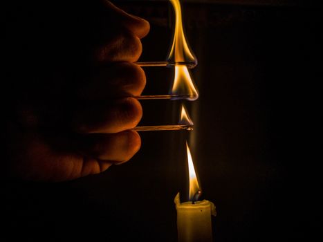 Matches burning to light a candle on black background