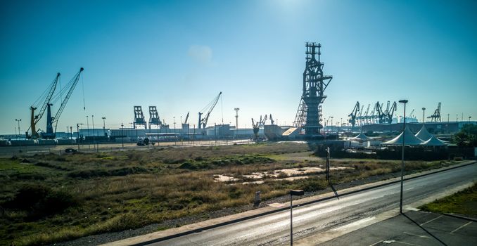 View of the old blast furnace exposed at a roundabout in the Port of Sagunto with the cranes of the commercial port in the background