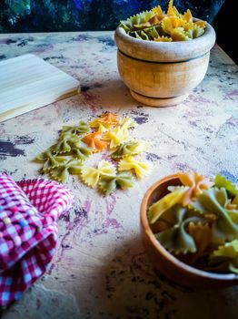 Colorful pasta ties in composition on light and rough background