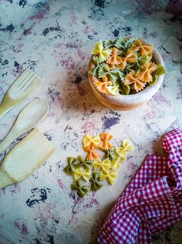 Colorful pasta ties in composition on light and rough background