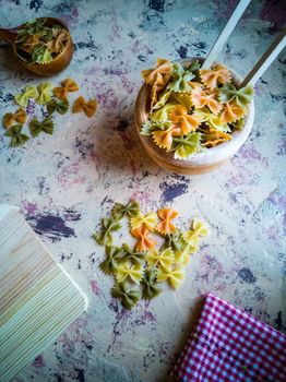Colorful pasta ties in composition on light and rough background