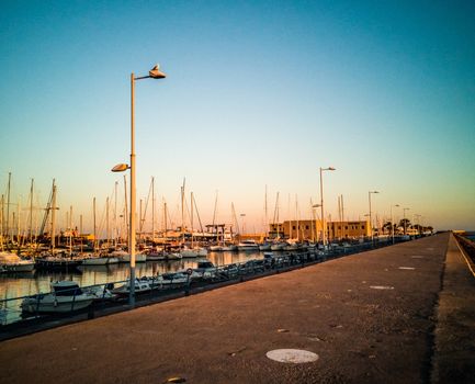 Harbor of Burriana at sunset with a seagull on a street lamp
